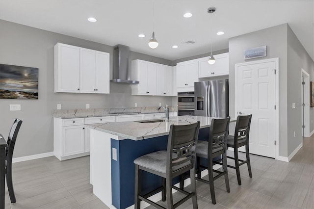 kitchen featuring stainless steel appliances, white cabinetry, a sink, and wall chimney range hood