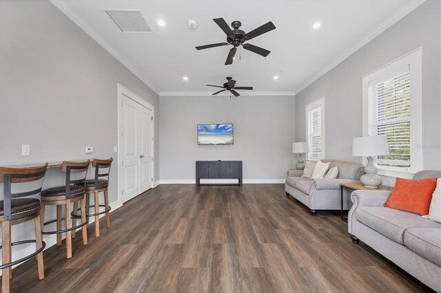 living area featuring recessed lighting, visible vents, ornamental molding, dark wood-type flooring, and baseboards