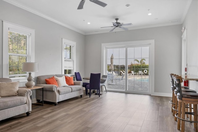 living room featuring plenty of natural light, crown molding, and wood finished floors