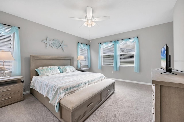 bedroom featuring light carpet, baseboards, and a ceiling fan