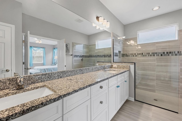 ensuite bathroom featuring double vanity, walk in shower, a sink, and ensuite bathroom