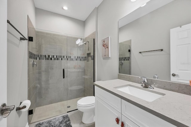 bathroom with vanity, a shower stall, and toilet