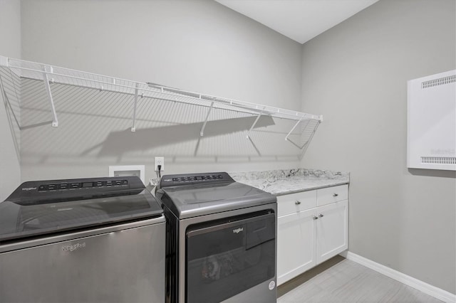 laundry room with washer and clothes dryer, cabinet space, and baseboards