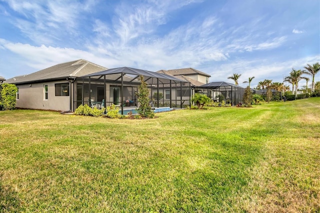 back of house featuring glass enclosure, an outdoor pool, and a lawn