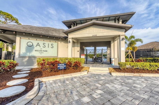 view of exterior entry featuring fence and stucco siding