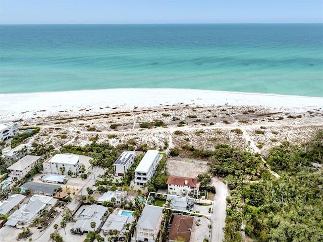 birds eye view of property with a water view and a beach view