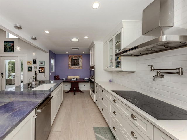 kitchen featuring range hood, stainless steel appliances, white cabinets, and sink