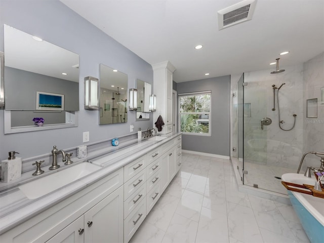 bathroom featuring a shower with shower door and vanity