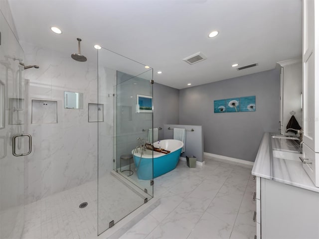 bathroom with vanity and shower with separate bathtub