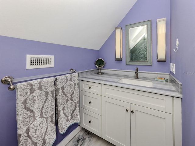 bathroom featuring lofted ceiling and vanity