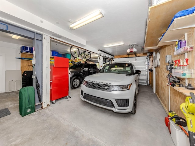 garage with a garage door opener and wooden walls