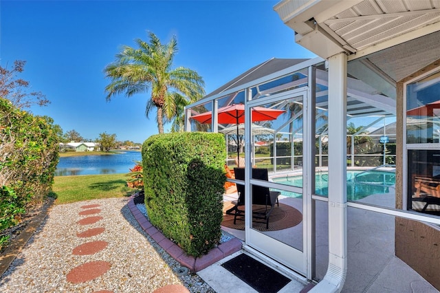 view of patio featuring a water view and a lanai