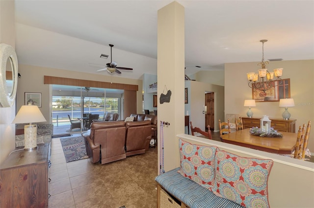 living room with ceiling fan with notable chandelier and vaulted ceiling