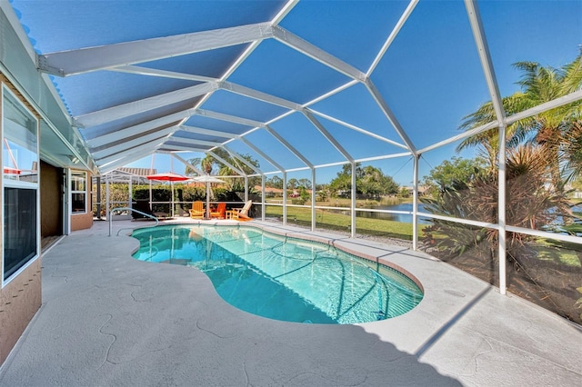 outdoor pool featuring glass enclosure, a water view, and a patio area
