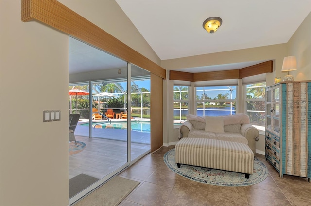 interior space with a water view, vaulted ceiling, tile patterned floors, and a wealth of natural light