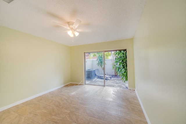 tiled empty room with ceiling fan and a textured ceiling