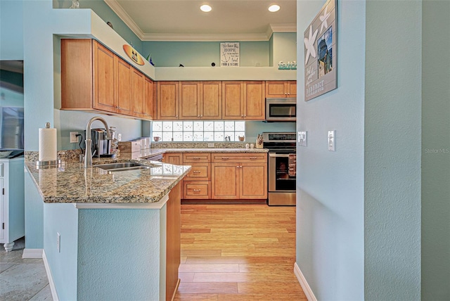 kitchen featuring appliances with stainless steel finishes, sink, ornamental molding, light stone counters, and kitchen peninsula