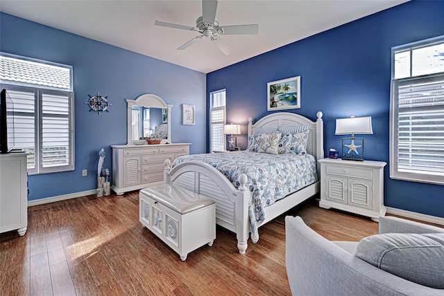 bedroom featuring multiple windows, hardwood / wood-style flooring, and ceiling fan