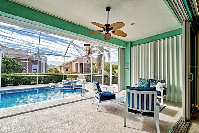 view of swimming pool featuring an in ground hot tub, ceiling fan, glass enclosure, and a patio