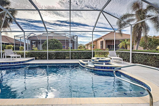 view of pool with an in ground hot tub, glass enclosure, and a patio area