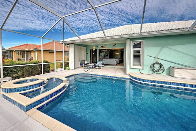 view of pool with a patio area, glass enclosure, ceiling fan, and an in ground hot tub