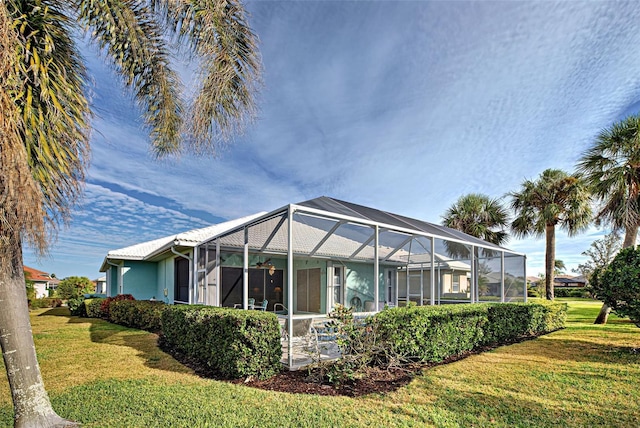 back of property with a lanai and a yard