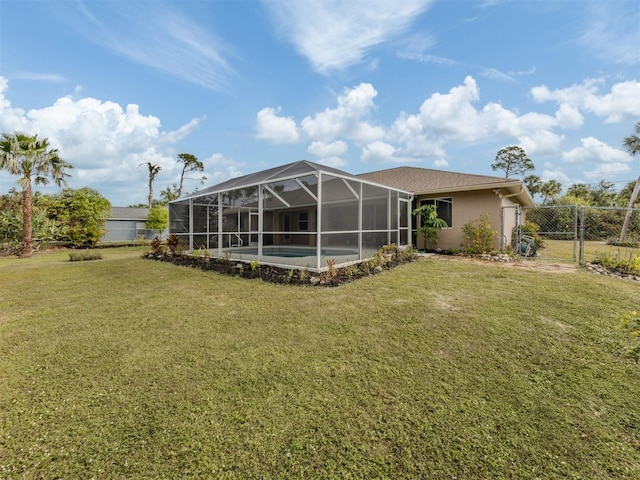 rear view of house with a fenced in pool and a lawn