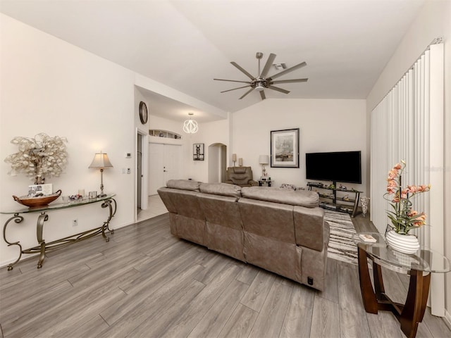 living room with ceiling fan, light hardwood / wood-style floors, and lofted ceiling