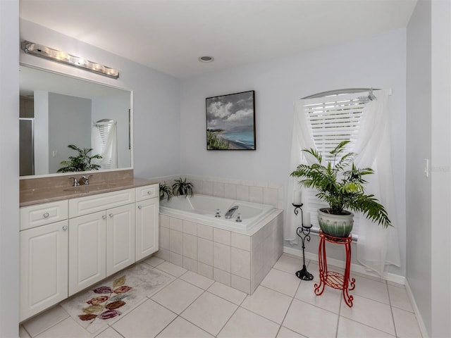 bathroom featuring tiled bath, tile patterned floors, and vanity