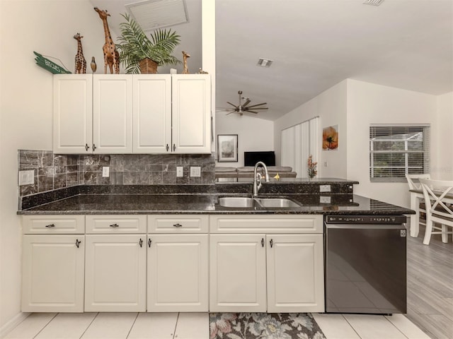 kitchen featuring sink, white cabinetry, black dishwasher, dark stone countertops, and lofted ceiling