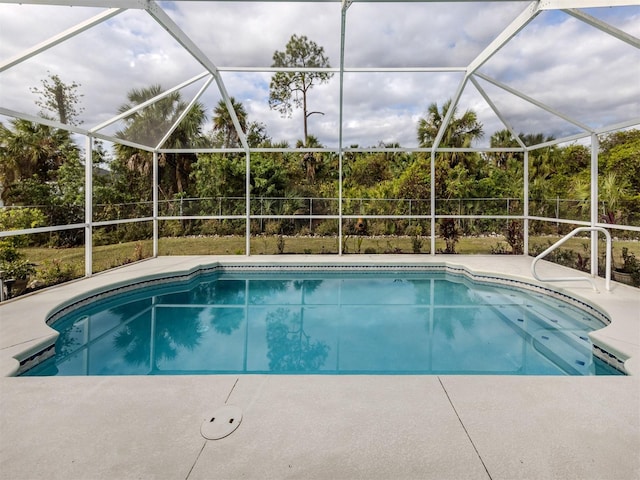 view of swimming pool with glass enclosure and a patio area