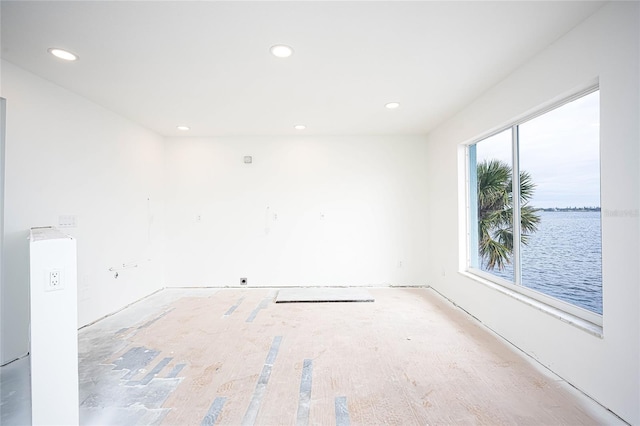 unfurnished room featuring a water view