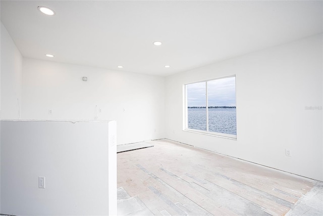 unfurnished room with a water view