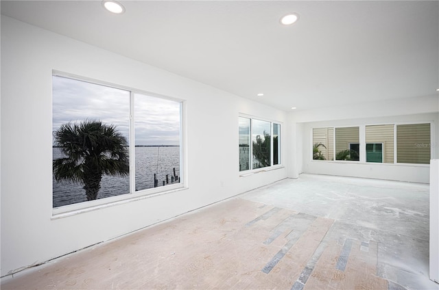 unfurnished room featuring a water view