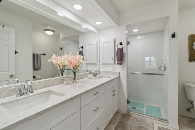 bathroom with vanity, toilet, an enclosed shower, and tile patterned flooring