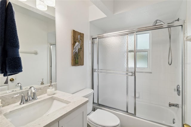 full bathroom featuring vanity, toilet, and combined bath / shower with glass door