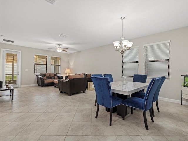 tiled dining area featuring ceiling fan with notable chandelier