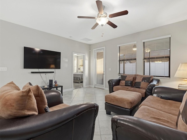 living room featuring ceiling fan, light tile patterned floors, and a healthy amount of sunlight