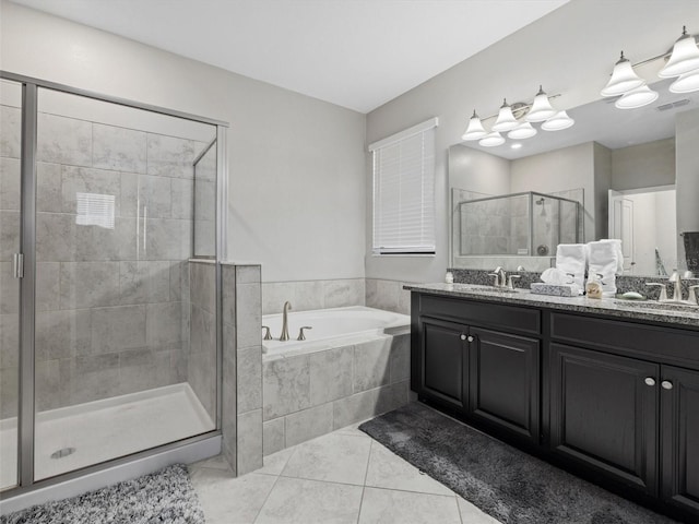 bathroom featuring plus walk in shower, vanity, and tile patterned flooring