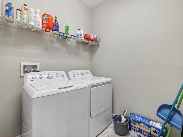 clothes washing area with independent washer and dryer and light tile patterned flooring