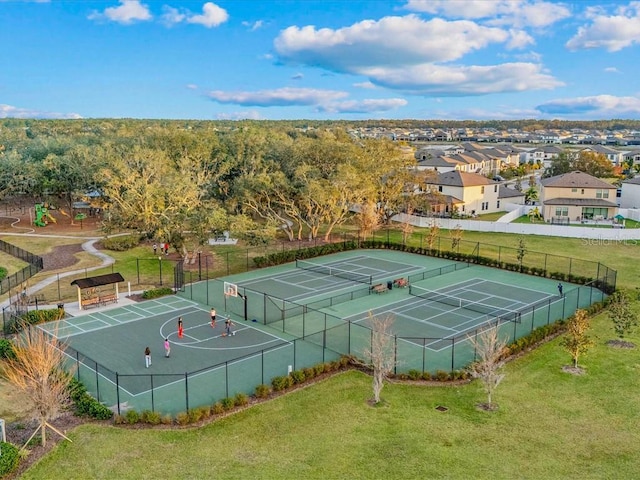 view of tennis court featuring a lawn