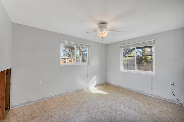 unfurnished room featuring plenty of natural light and ceiling fan