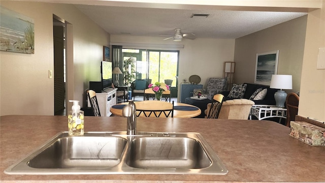 kitchen featuring sink, a textured ceiling, and ceiling fan