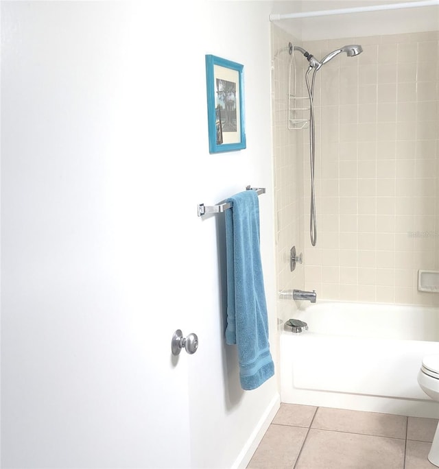 bathroom with tile patterned floors, toilet, and tiled shower / bath