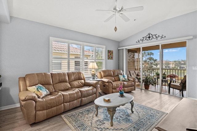 living room with hardwood / wood-style floors, plenty of natural light, ceiling fan, and vaulted ceiling