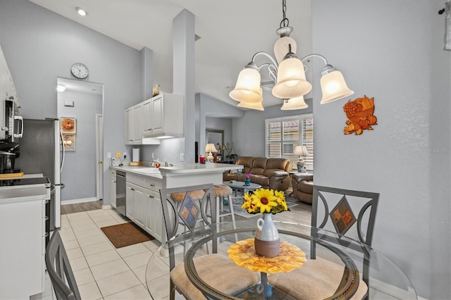 kitchen with pendant lighting, light tile patterned floors, stainless steel appliances, and white cabinets