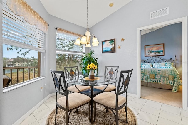 dining room featuring light tile patterned flooring, vaulted ceiling, and a notable chandelier