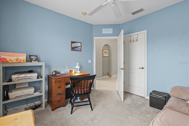 carpeted office space featuring ceiling fan