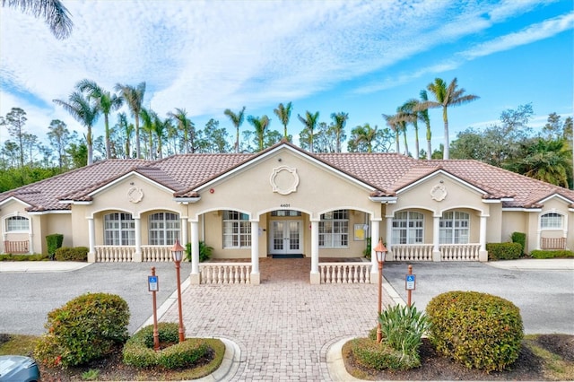 mediterranean / spanish-style house with french doors and covered porch