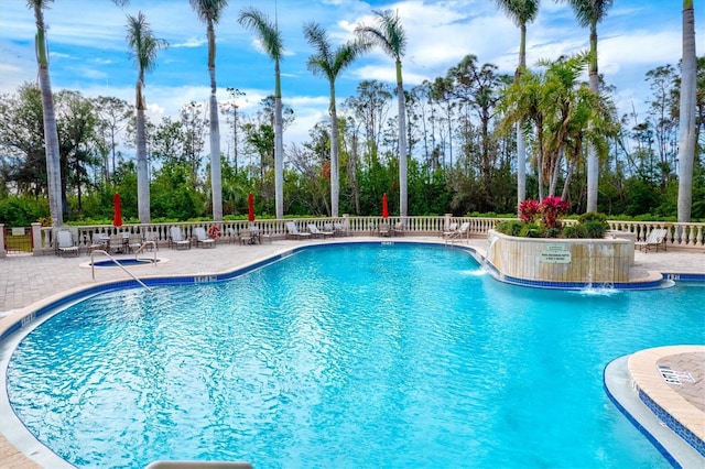 view of swimming pool with pool water feature and a patio